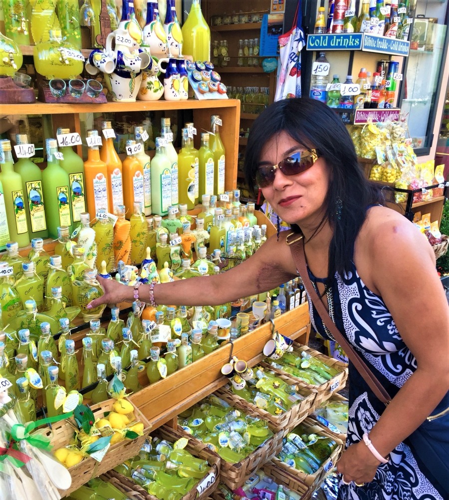Sampling limoncello in Capri at a colorful local shop filled with lemon bottles and ceramics