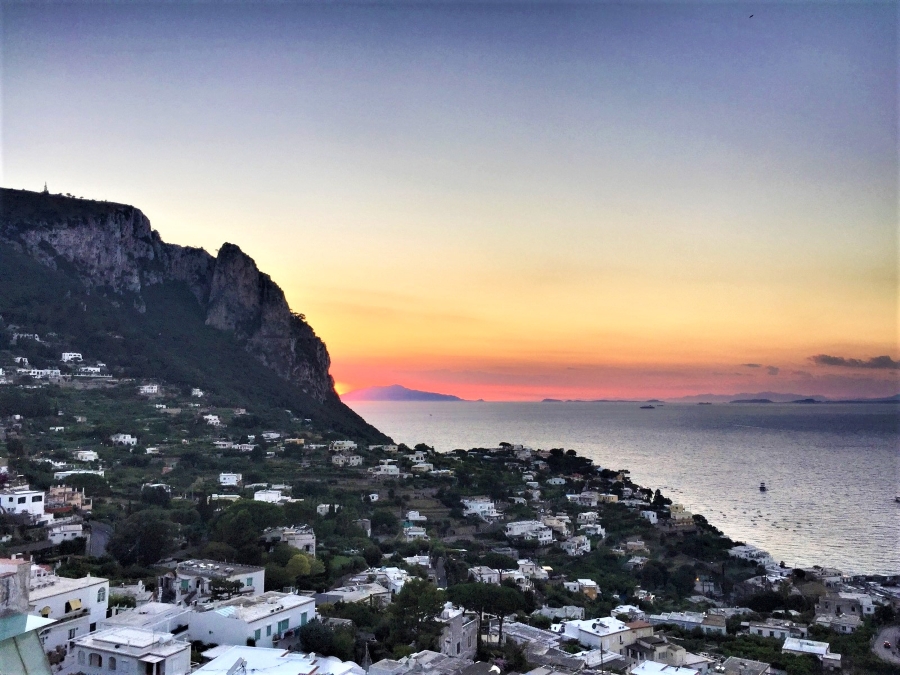 Sunset view over Capri, Italy, with golden light fading behind the cliffs and sea