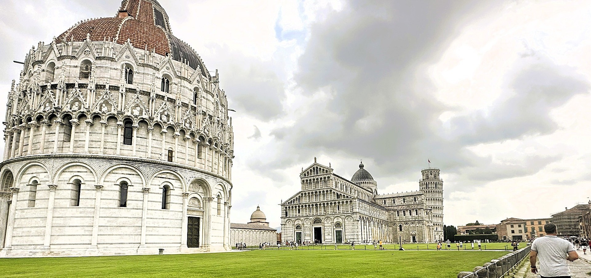 View of the Pisa Baptistery, Cathedral and Leaning Tower in the Piazza dei Miracoli on a cloudy day in Tuscany, Italy