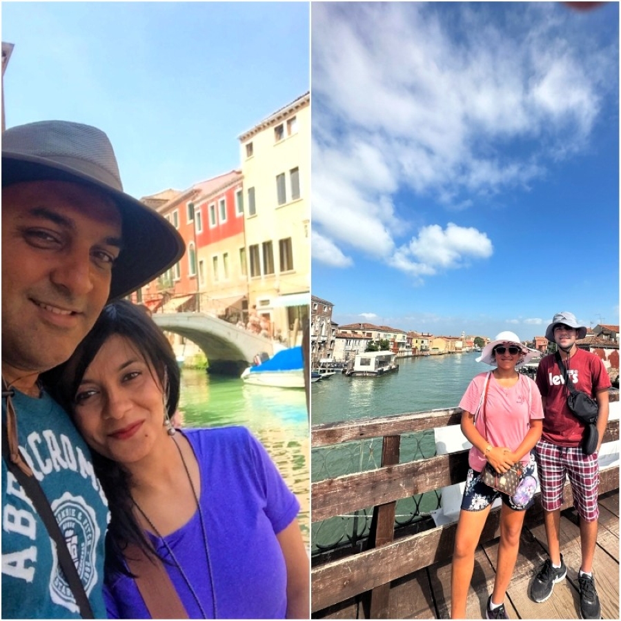 Travelers enjoying a canal stroll and bridge view in Murano, Italy, surrounded by colorful Venetian houses.