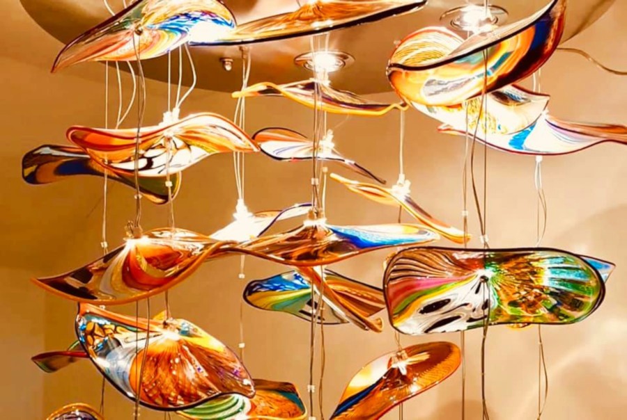 Colorful contemporary Murano glass installation with flowing shapes suspended from the ceiling, showcasing the island’s artistry in glassblowing and design