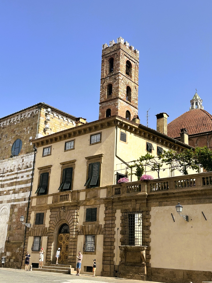 Walking along the streets of Lucca, Italy — historic buildings, stone façades, and medieval towers under the Tuscan sky