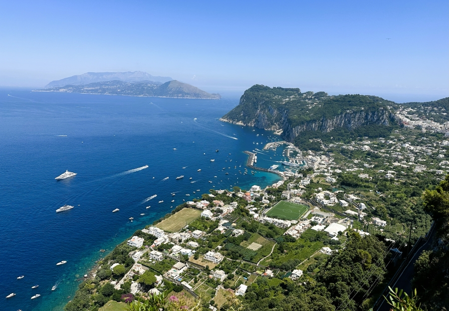 A panoramic view of Capri’s coastline, Marina Grande, and the cliffs rising toward Anacapri on a clear summer day