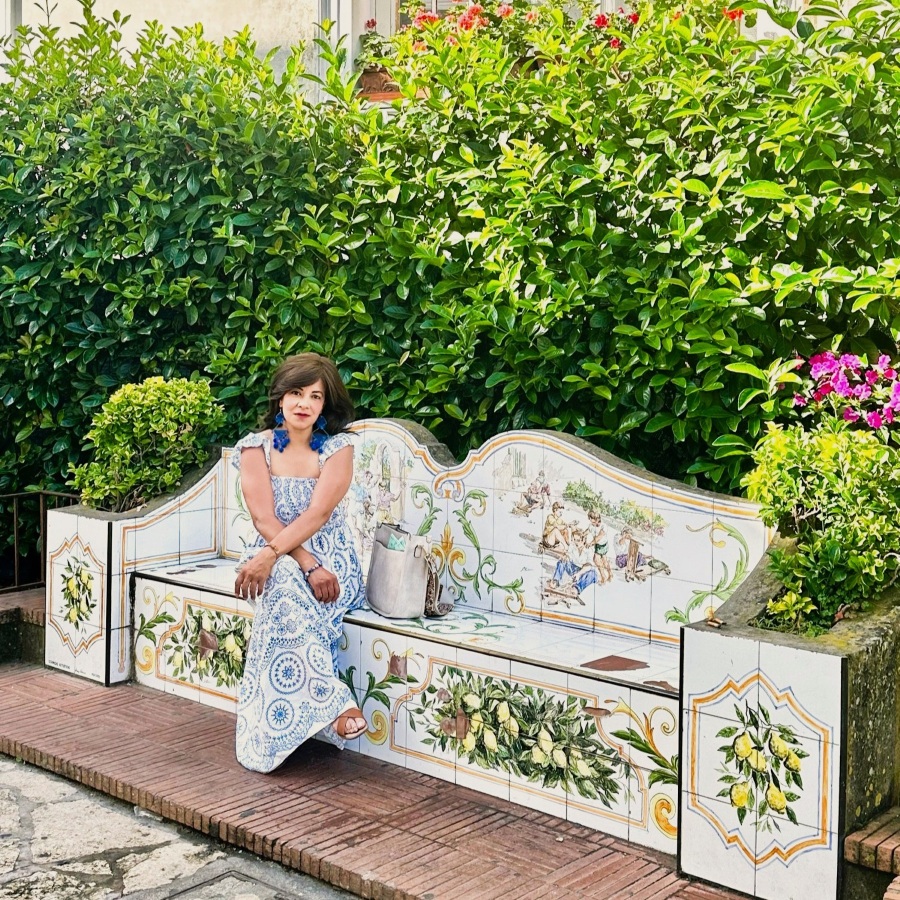 Hand-painted majolica bench in Anacapri featuring lemon motifs and traditional ceramic artwork, surrounded by greenery.