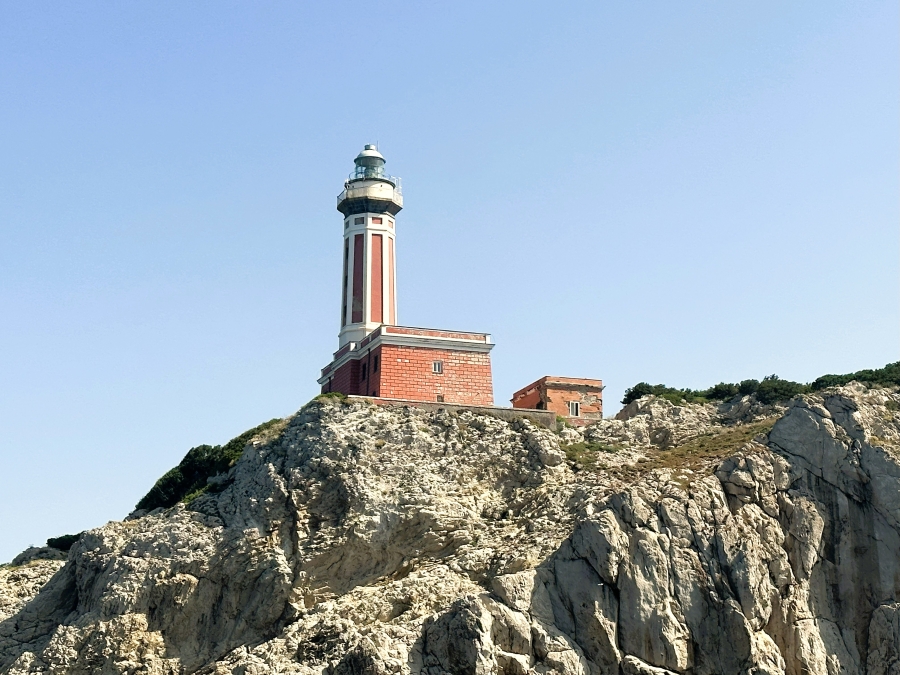 Punta Carena Lighthouse standing on the rocky cliffs of Anacapri under a clear blue sky