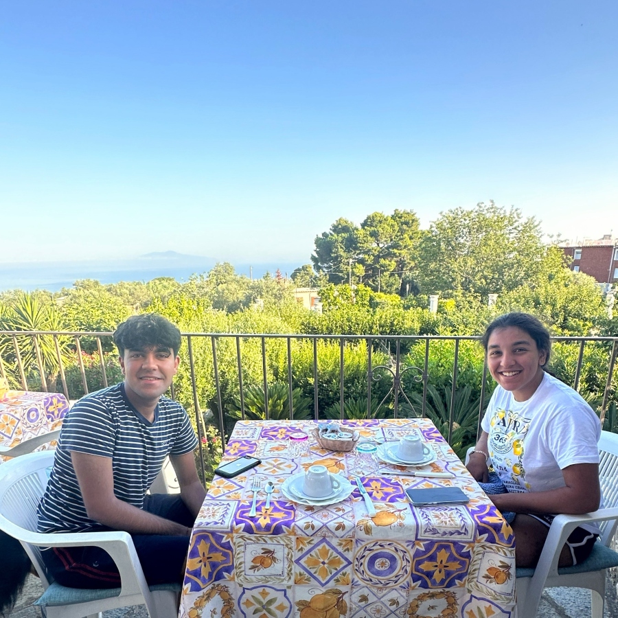 Breakfast on the terrace at the bed and breakfast Villa Damecuta in Anacapri, overlooking gardens and a distant view of the island of Ischia.