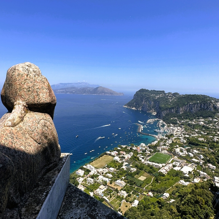 A sphinx statue at Villa San Michele in Anacapri overlooking Capri, Marina Grande, and the sea from high above.