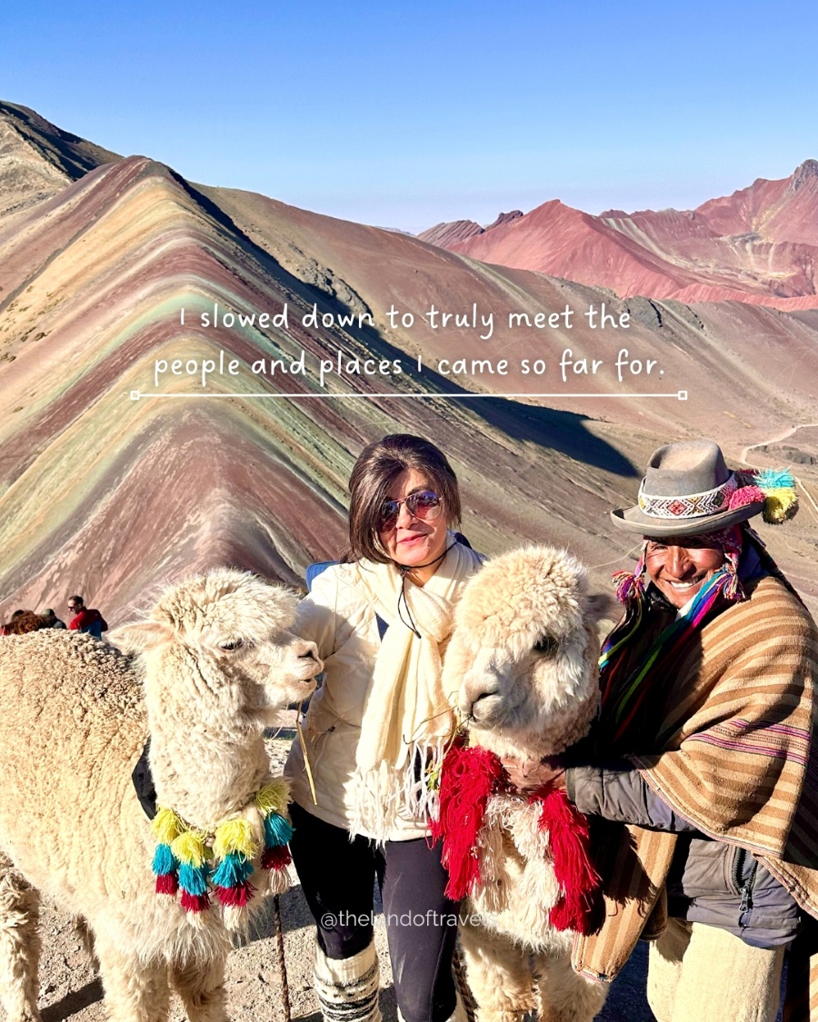 Traveler interacting with locals and alpacas at Rainbow Mountain in Peru